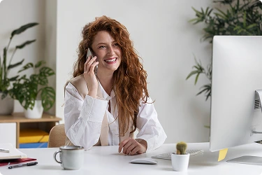 Smiling virtual administrative assistant on phone call at desk, representing seamless operational support for businesses